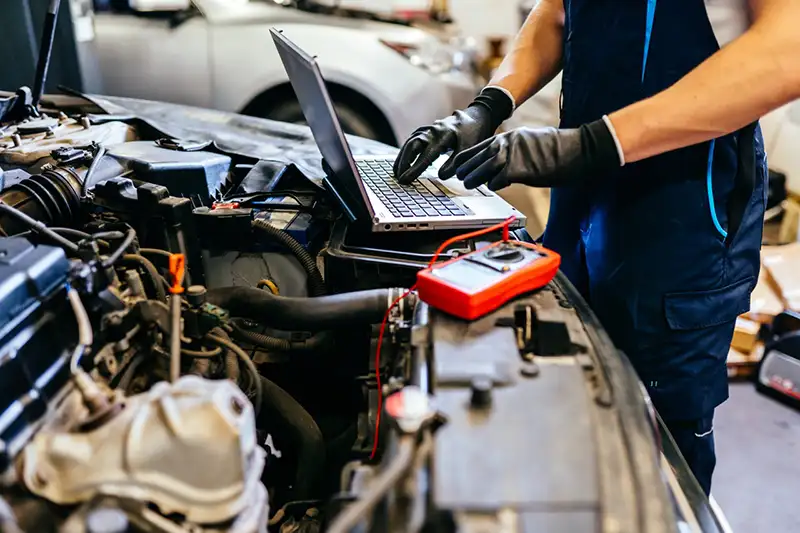 Mechanic working on advanced car diagnosis.